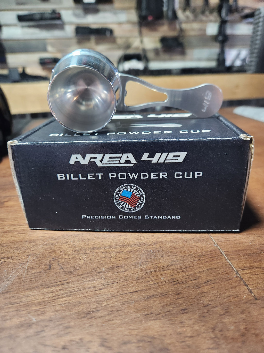 A black billet powder cup with engraved Area 419 logo mounted on a rifle stock by Area 419.