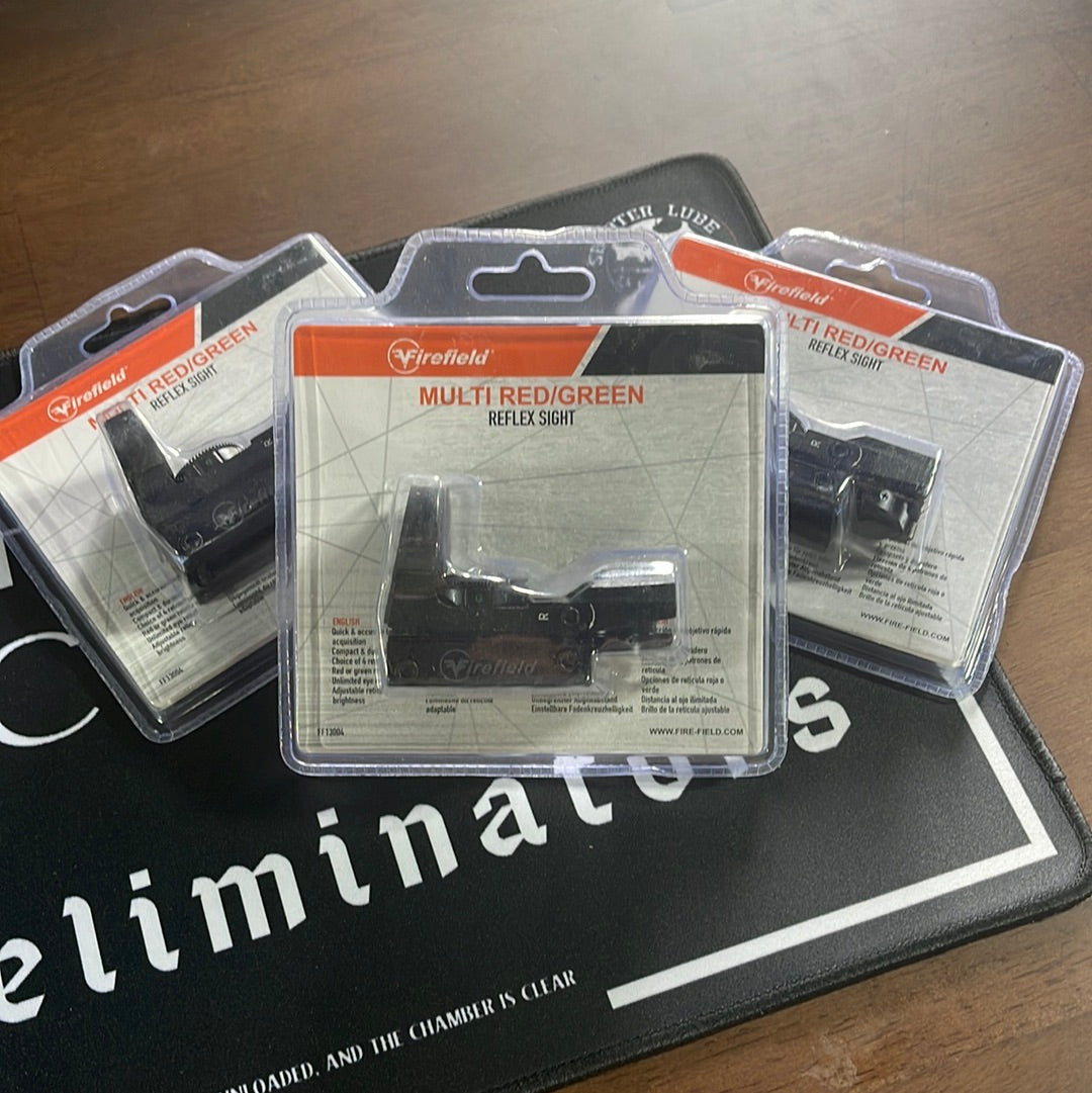 Three packaged Firefield Multi Red Green Reflex Sights are displayed on a dark surface, highlighting their sleek design.